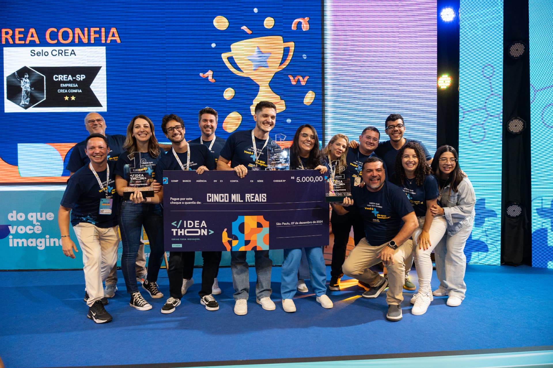 Time vencedor do Ideathon no palco com o cheque de premiação